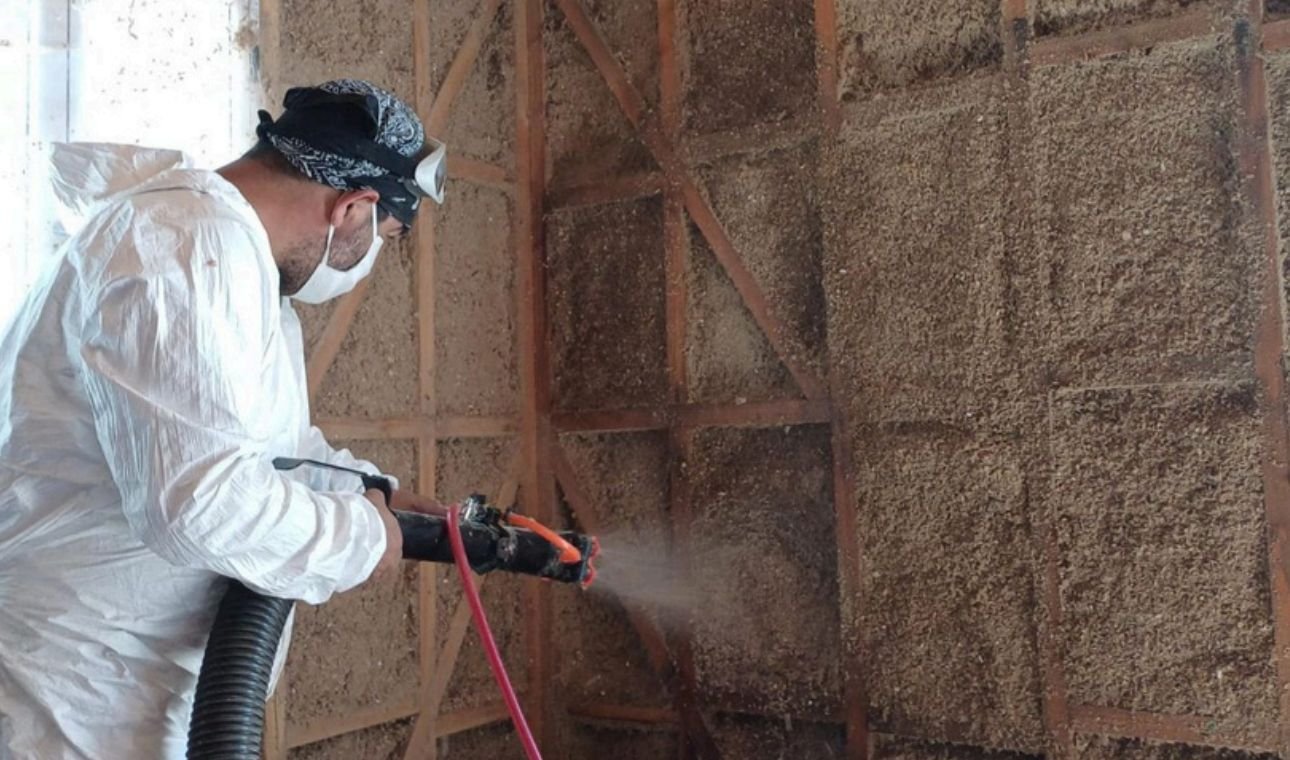 Operario de Lgm aplicando celulosa proyectada sobre la estructura de un muro