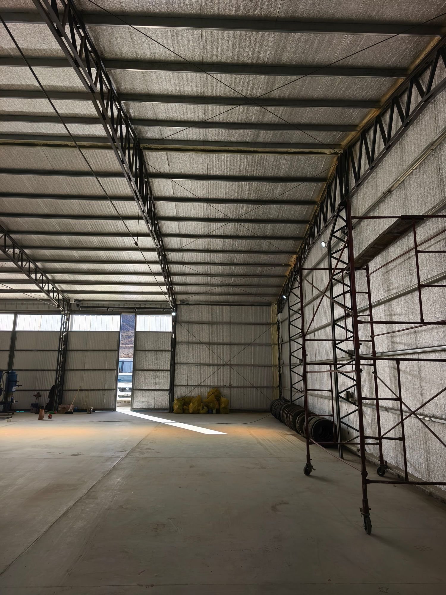 Interior de una nave industrial terminada, con cerramientos aislados y piso de hormigón
